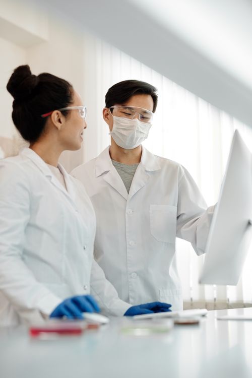 Deux professionnels de laboratoire échangent devant un écran